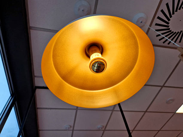 a lamp above the dining room table with gold lacquer and a lampshade bulb. it does not dazzle people, fan electric