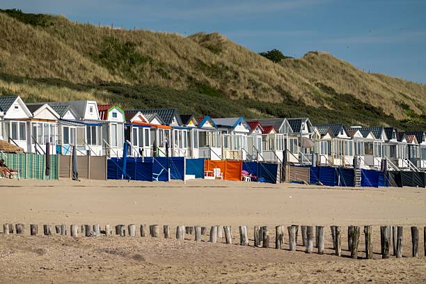 istock Colorful beach huts stretching along sandy coastline under summer sky 2216649956