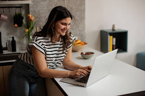 istock Woman on Laptop in Apartment Kitchen 2216654144