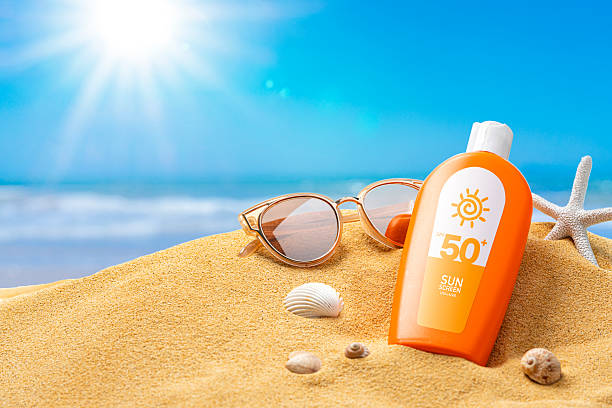 Suntan lotion or sun cream on the beach sand on a sunny day