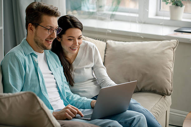 istock Happy Couple Using Laptop at Home 2216656556