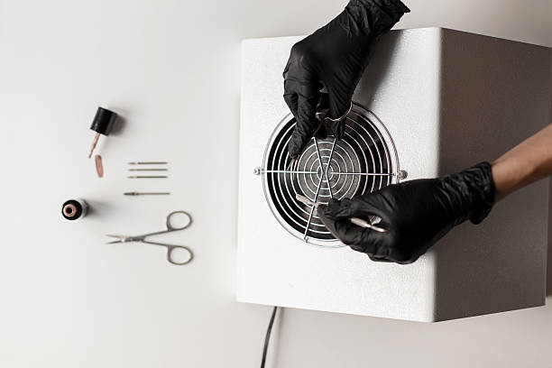 istock Nail care. Tools for nails. Female hands hold scissors over a vacuum cleaner. 2216656708