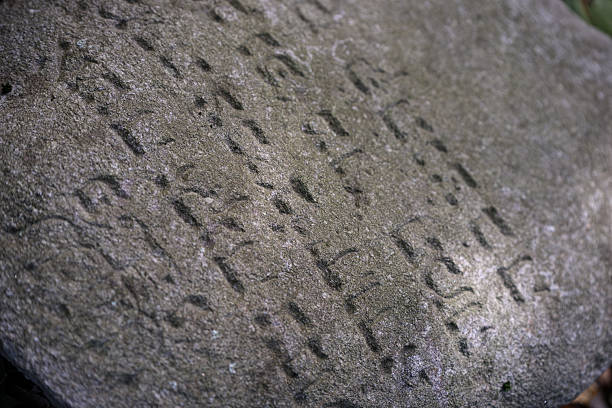 Surface of stone with carved symbols. Stone is over a hundred years old, text unknown.