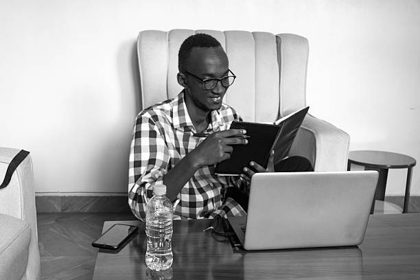 istock Man with Glasses Reading and Working on Laptop 2216659831