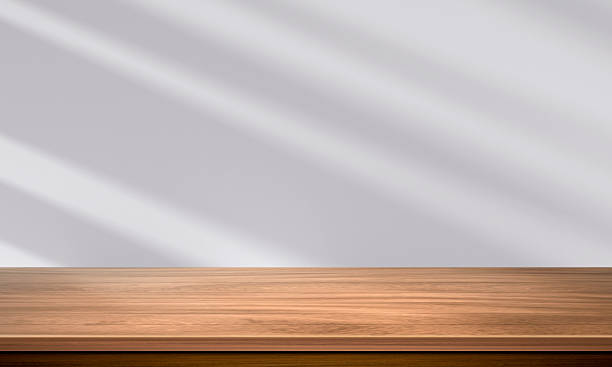 istock Wood table top and blurred wall shadow leaves window background can used for display or montage your products 2216660951