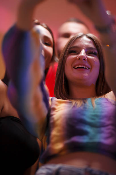 Young people dancing in neon light at rave party