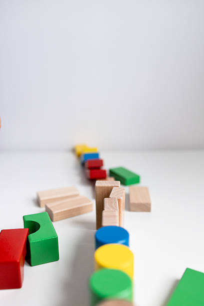 istock Colorful wooden toy blocks arranged in a creative pattern on white surface 2216671073