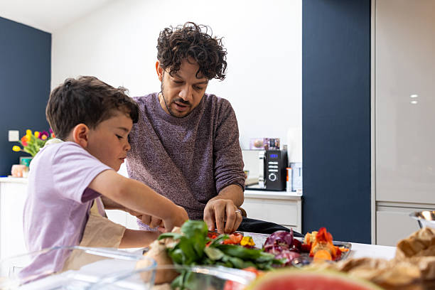 istock Young Boy Learns to Cook with His Dad at Home 2216673524