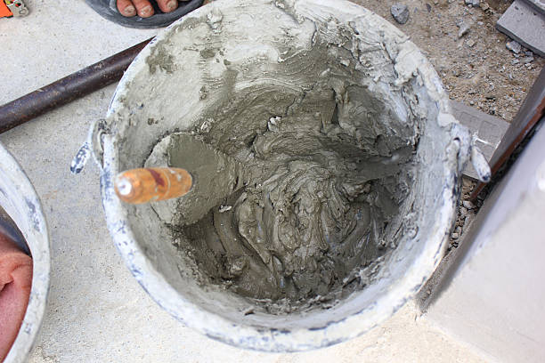 istock Bucket filled with wet cement and a trowel at construction site 2216674423