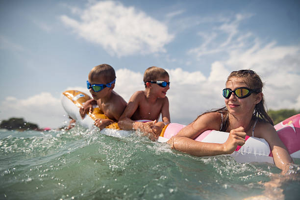istock Three kids floating on a colorful inflatable, enjoying a sunny day at the beach 2216674673