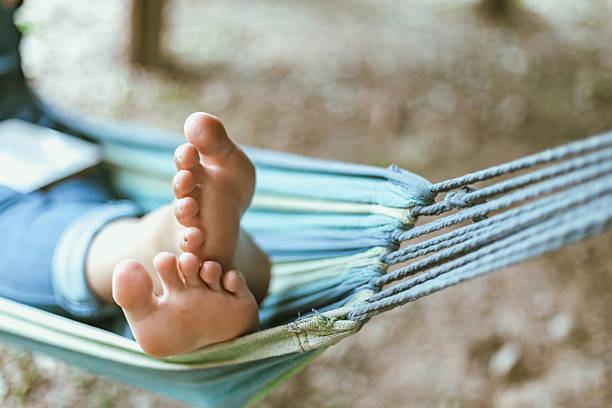 Happy young woman relaxing in a hammock in the garden