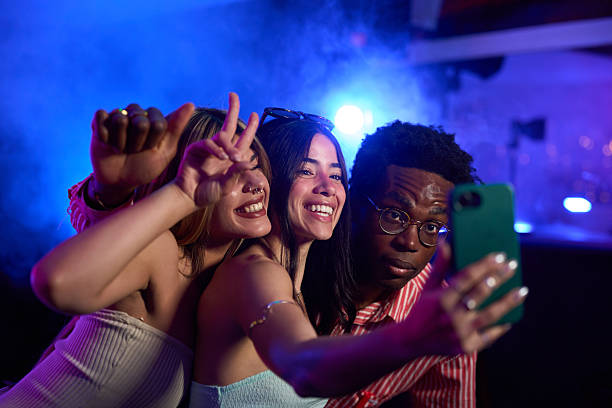 istock Young adults taking a group selfie at a party 2216676131