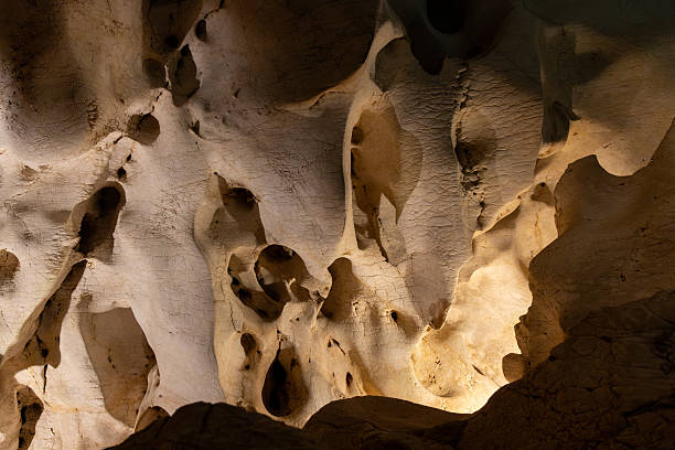 istock Intricate cave wall texture illuminated by soft lighting, showcasing natural formations and shadows, creating a captivating atmosphere of geological beauty and mystery 2216678670
