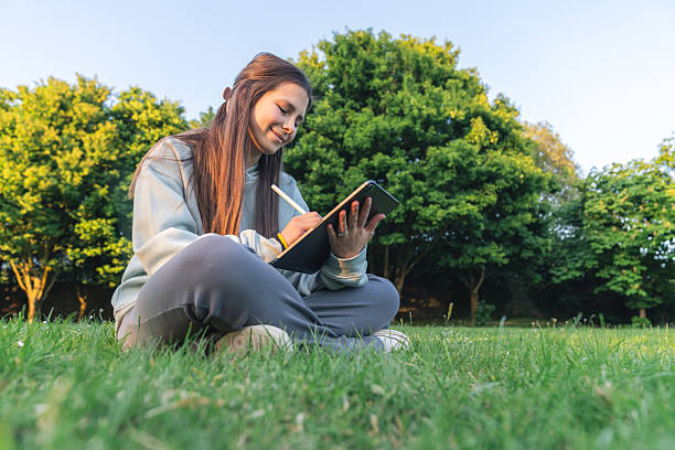 istock Young woman writing in a notebook outdoors 2216680962