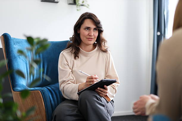 istock Young caucasian female therapist taking notes during counseling session 2216685996