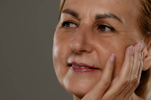 istock Thoughtful Mature Woman with Hand on Face Close Up 2216686213