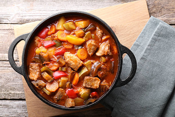 istock Delicious stew with vegetables in pot on wooden table, top view 2216689618