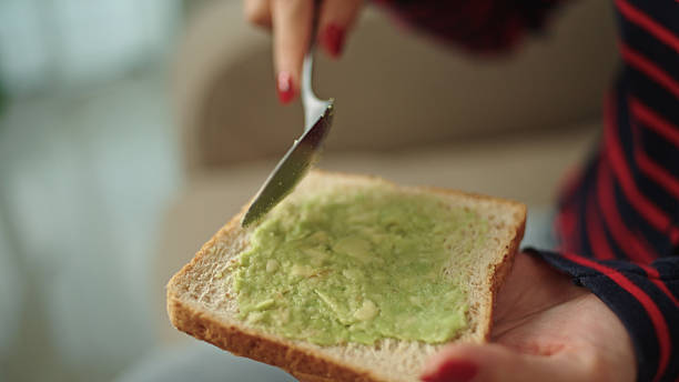 istock Teenager spreading avocado on toast. 2216692682