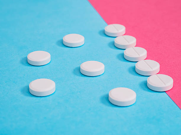 istock White pills scattered across a blue and red surface. 2216692735
