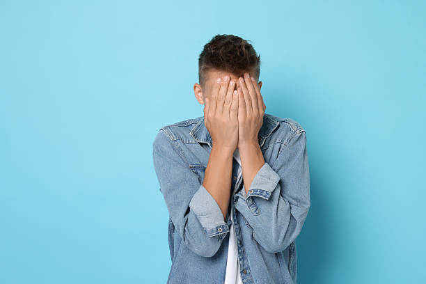 istock Portrait of scared young man on light blue background 2216693318