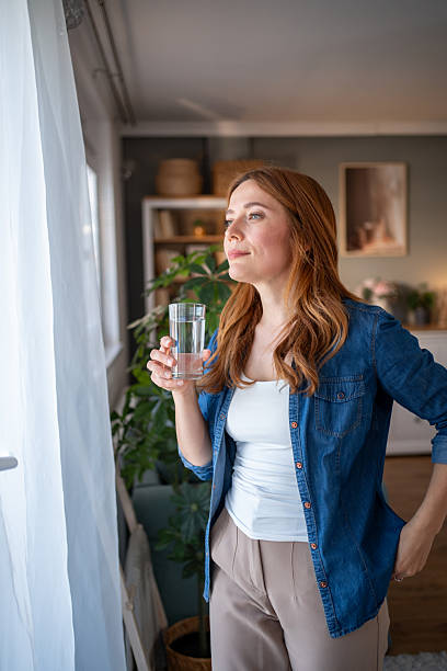 istock Woman enjoying a refreshing drink at home 2216693583