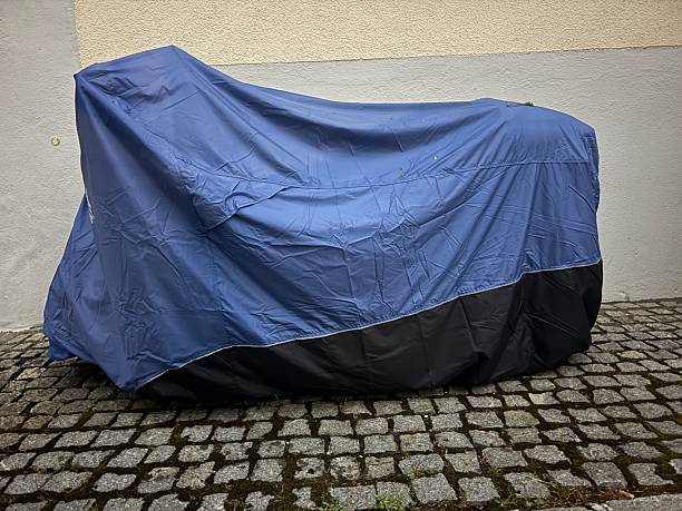 istock Blue and black motorcycle cover is draped over a motorcycle 2216695933