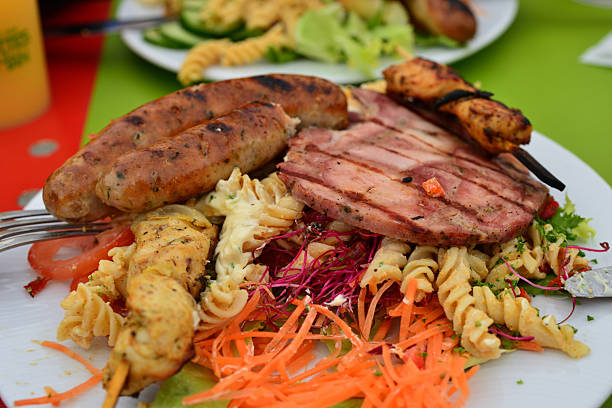Hearty Ardennes lunch. Roasted chicken, Ardennes roasted ham, fusilli spaghetti, grated carrots and beetroot, tomato slices, salad with mayonnaise