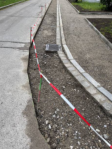 istock Road with a red and white striped barrier and a drainage grate 2216696739