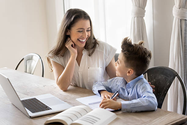 istock Cute kid boy and happy young mom doing school homework 2216696984
