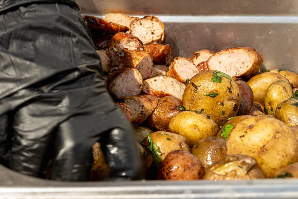 istock Hand grabbing sour potatoes and sliced chorizos from a container. 2216698430