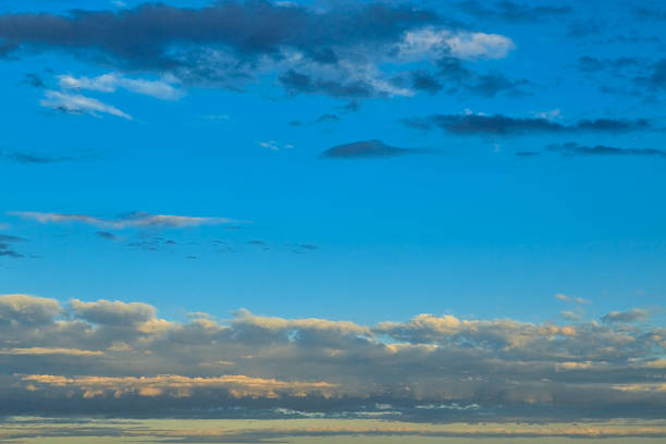 Golden sunset behind clouds: soft light transitions. Sun rays pierce through the clouds, creating a \
