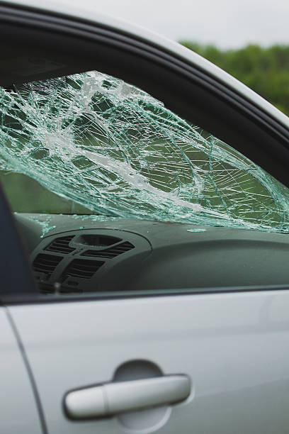 istock Interior view of car with shattered windshield and scattered glass. Cracks spread across safety glass above dashboard. 2216701311