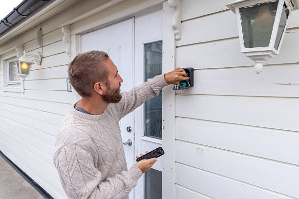 istock Man Accessing Key Safe on House Wall with Smartphone 2216707171