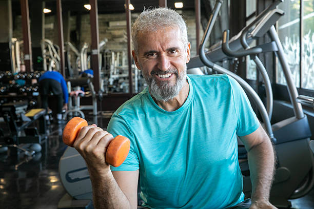istock Senior Man Having Strength Exercise in Gym with Weights 2216708013