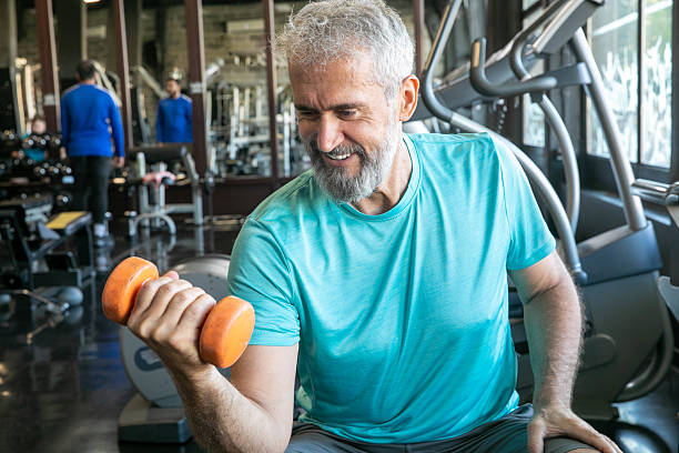 istock Senior Man Having Strength Exercise in Gym with Weights 2216708036