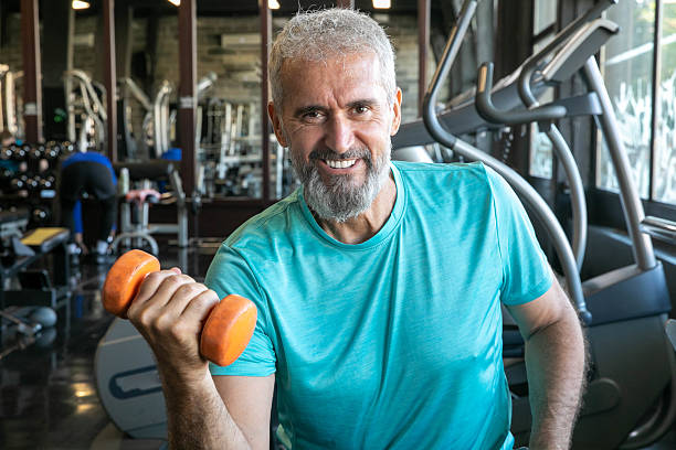 istock Senior Man Having Strength Exercise in Gym with Weights 2216708037