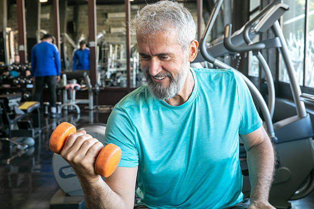 istock Senior Man Having Strength Exercise in Gym with Weights 2216708041