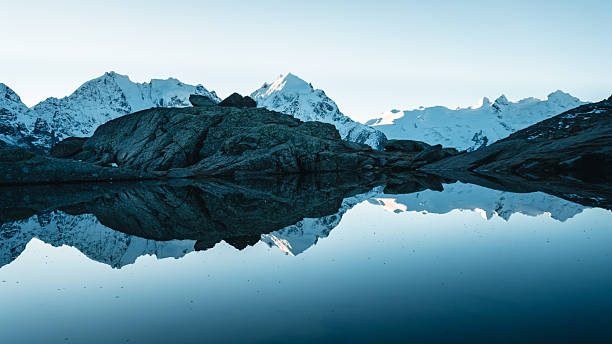 istock View across calm lake and mountain reflection, Engadine Alps 2216711683