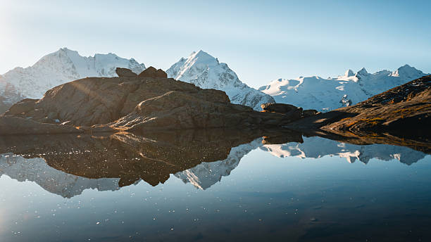 istock View across calm lake and mountain reflection, Engadine Alps 2216711717
