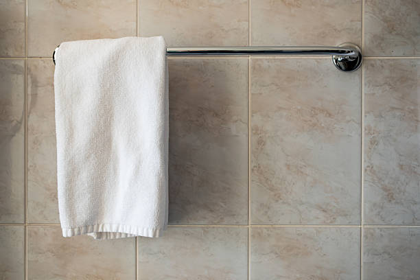 istock A white towel is hanging on a background of ceramic tiles 2216716733