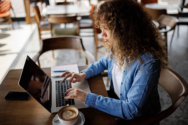 istock Young woman working on laptop at a cafe 2216717662