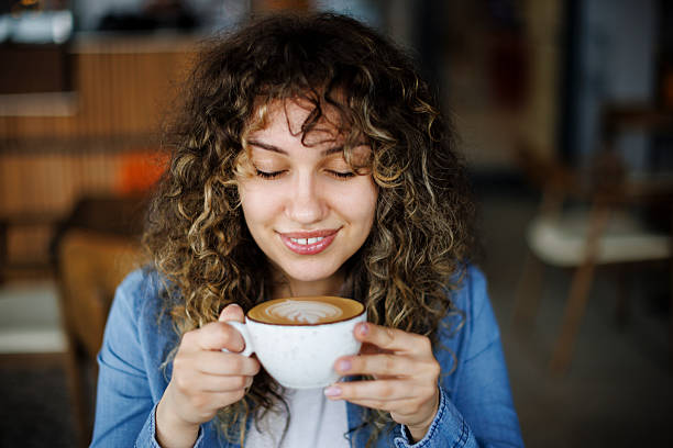 istock Young woman enjoying coffee at a cafe 2216718005