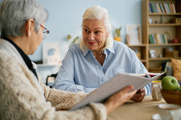 istock Senior Women Enjoying Conversation While Reading Book 2216719901