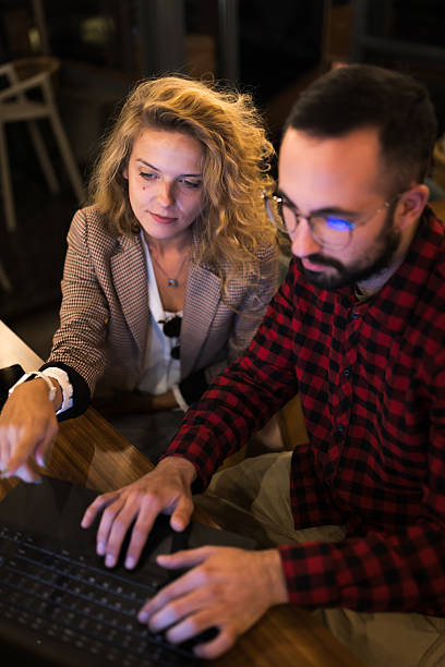 istock Two colleagues collaborating on a project, focusing on a laptop screen to solve problems and generate ideas in an office environment. 2216720796