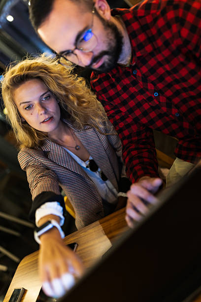 istock Focused team collaboration in a modern workspace with man and woman engaged in computer work, showcasing teamwork and technology. 2216720803
