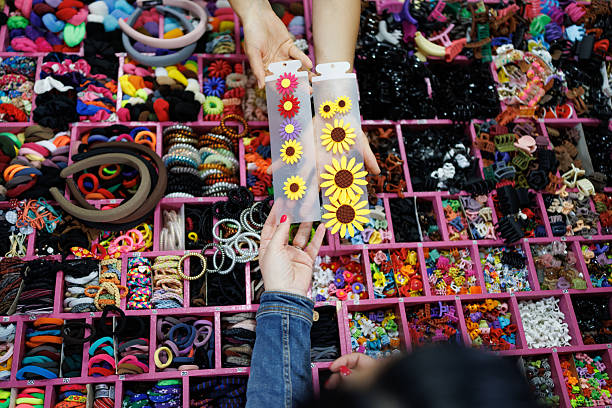 Close up of unrecognizable people holding Fashion Hair Clips and Decor Items at market stall