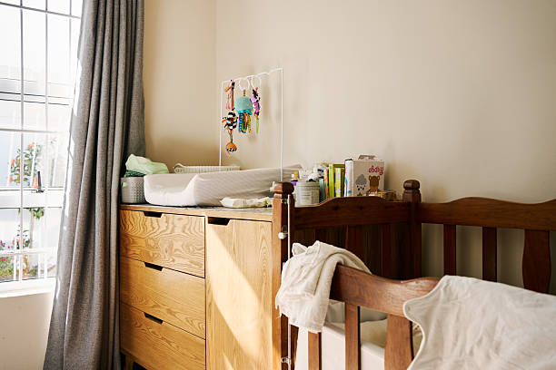 Cozy baby room featuring a wooden crib and a changing table adorned with colorful baby products and playful toys