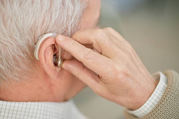 istock Adjusting Hearing Aid with Focus on Elderly Person 2216728179
