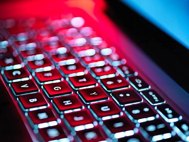 istock Close-up of a red laptop keyboard, glowing brightly in a dark setting, showcasing technology. 2216731087
