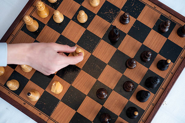 istock a hand playing a chess move by moving a chess piece on a chess board 2216732963